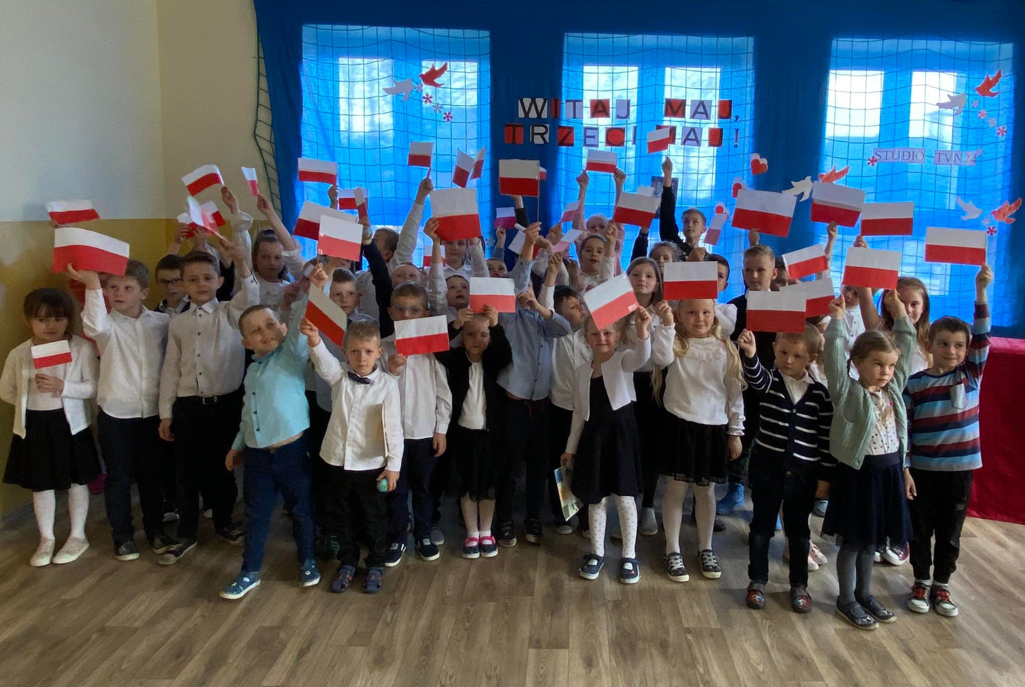 Dzieci trzymające flagi Polski - akcja #3maj flagę